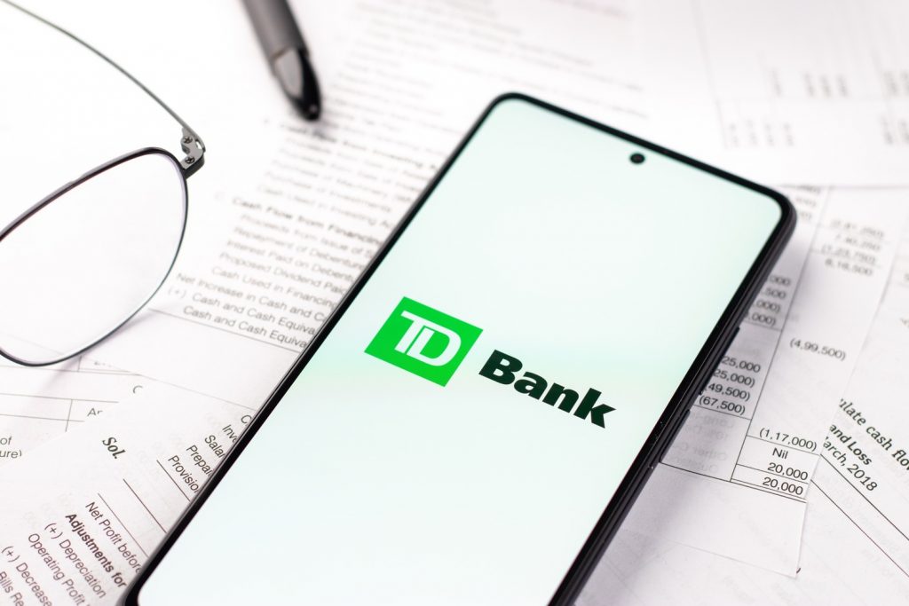 TD Bank overdraft fee documents and smartphone to call