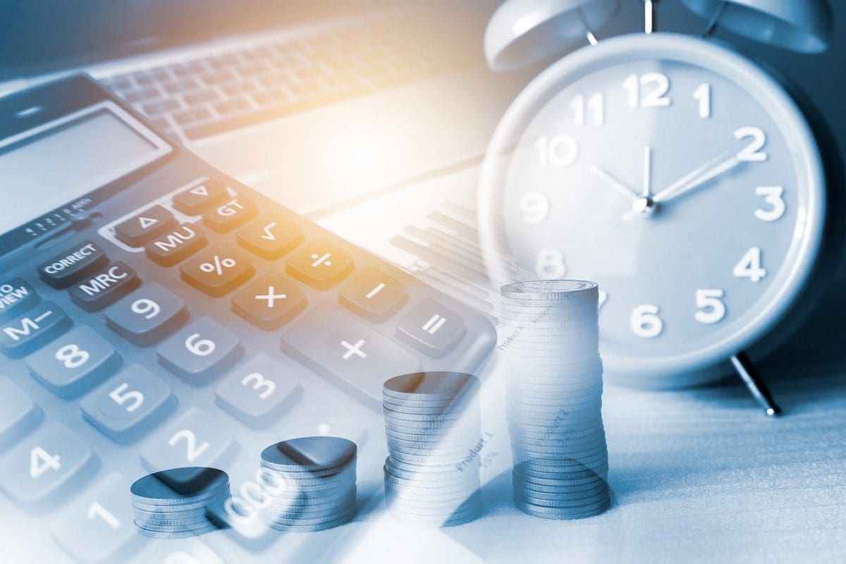 Conceptual representation of financial timing and value with coins, a calculator, and a clock
