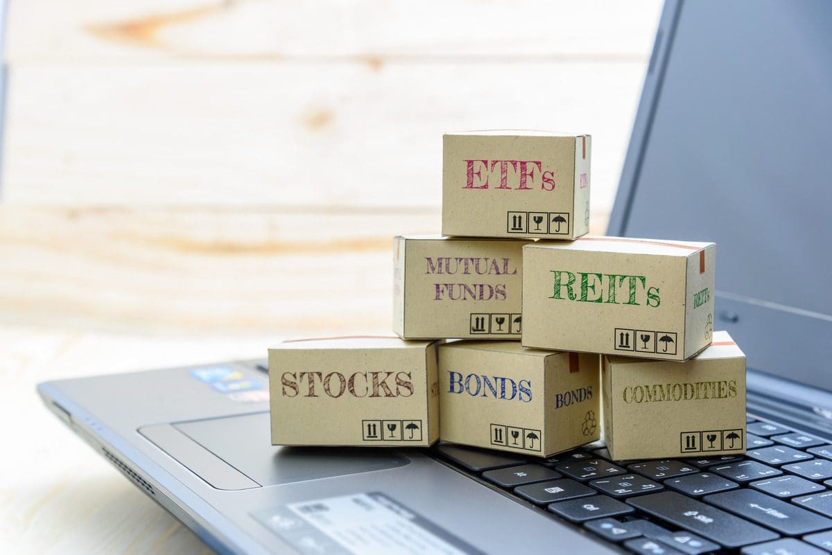Miniature boxes labeled ETFs and Mutual Funds on a keyboard representing retail investment options