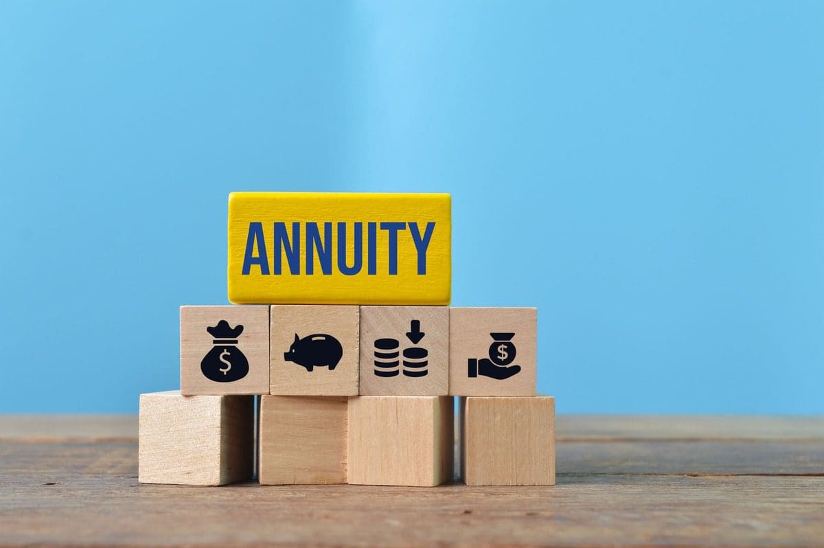 Wooden blocks with financial symbols and the word ANNUITY representing retirement planning strategies.