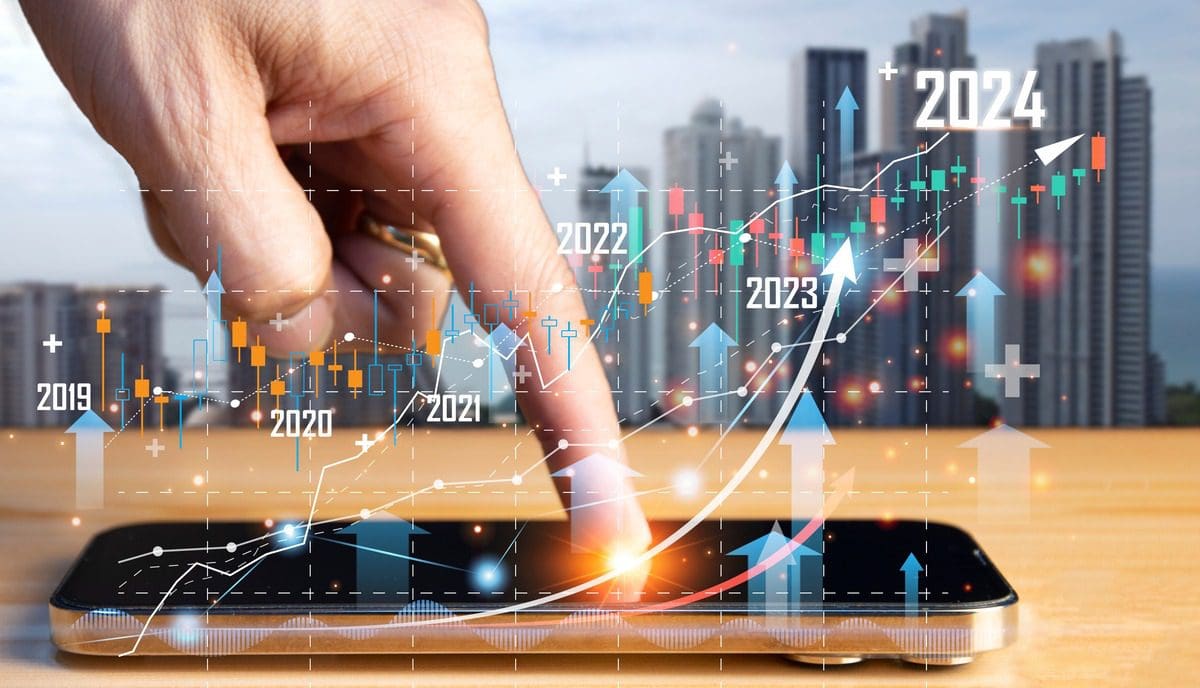 A smartphone screen displaying a financial growth chart over a cityscape background symbolizing the evolution of digital investments.