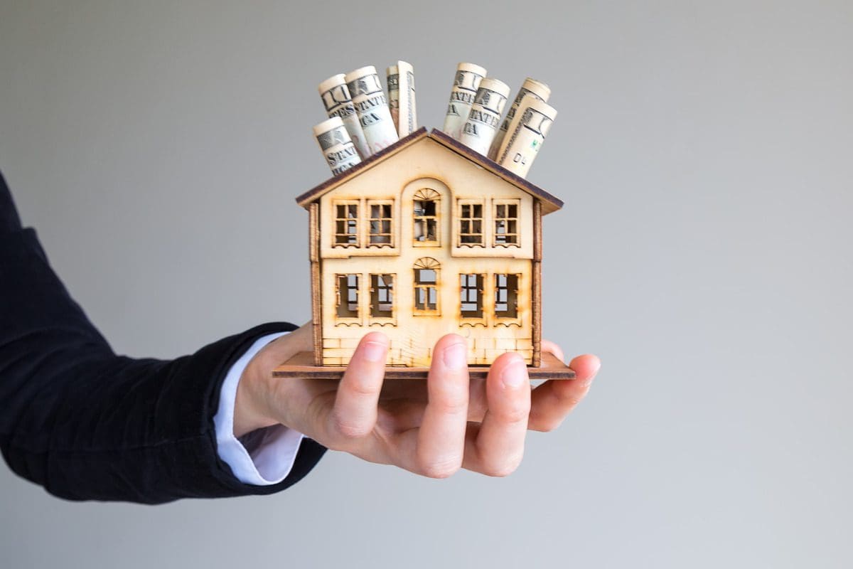 Hand holding wooden house model