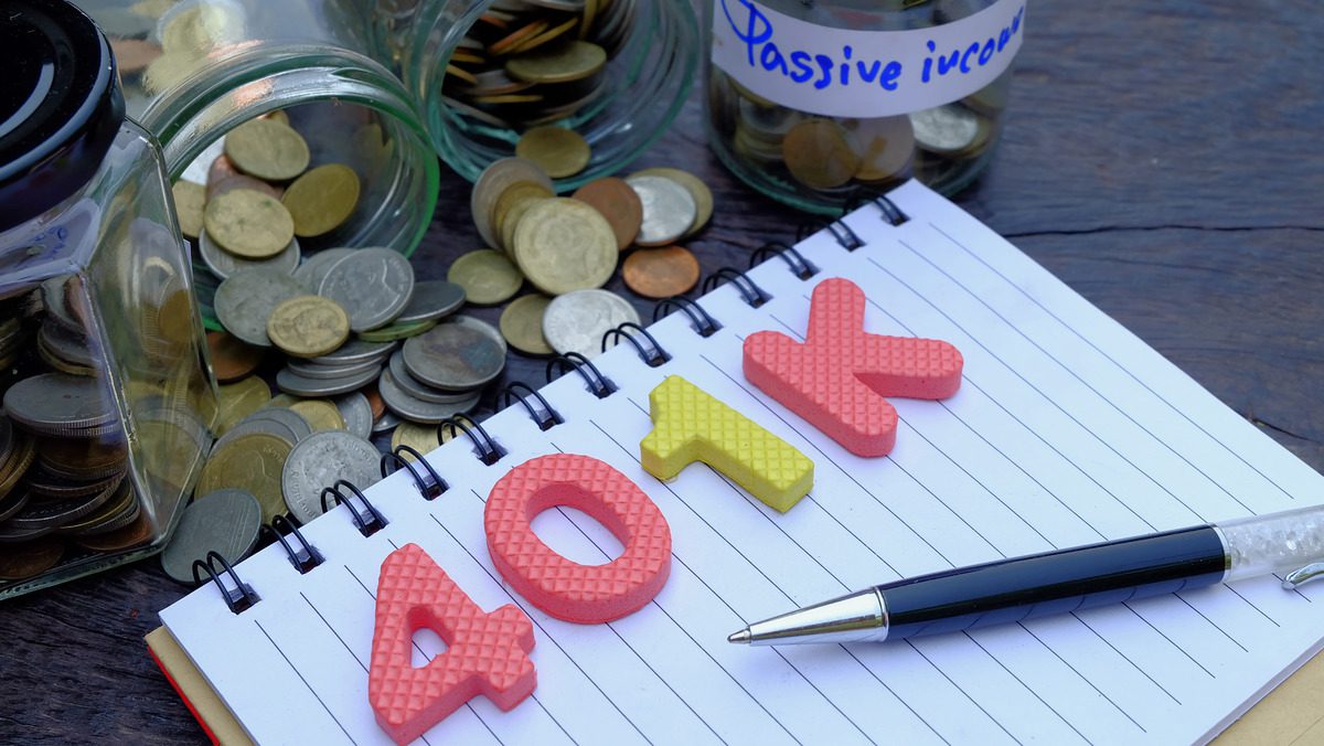 Retirement planning concept showing a 401k notebook and savings jars.