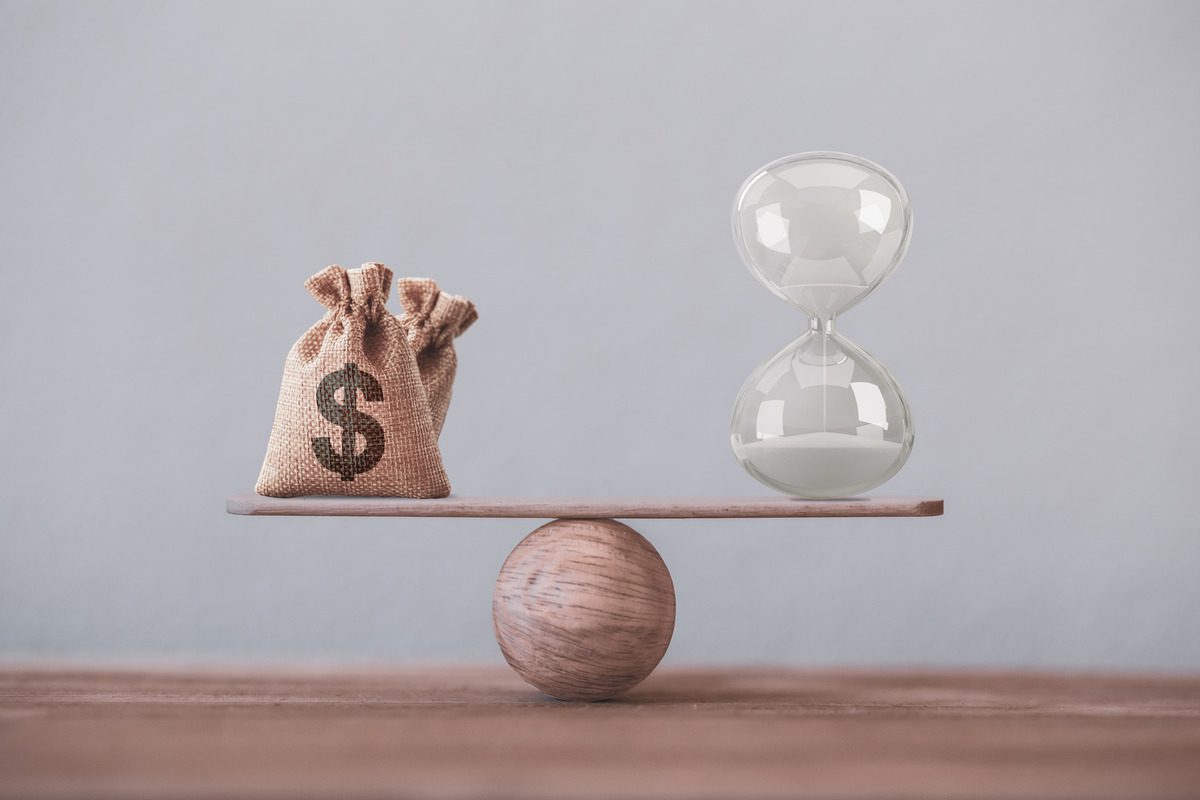Money bag and hourglass on scale