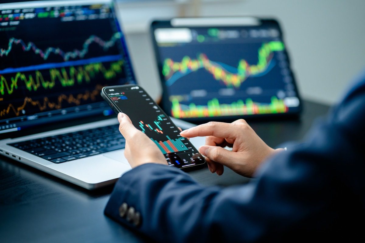 A person using a smartphone to view live cryptocurrency trading charts.