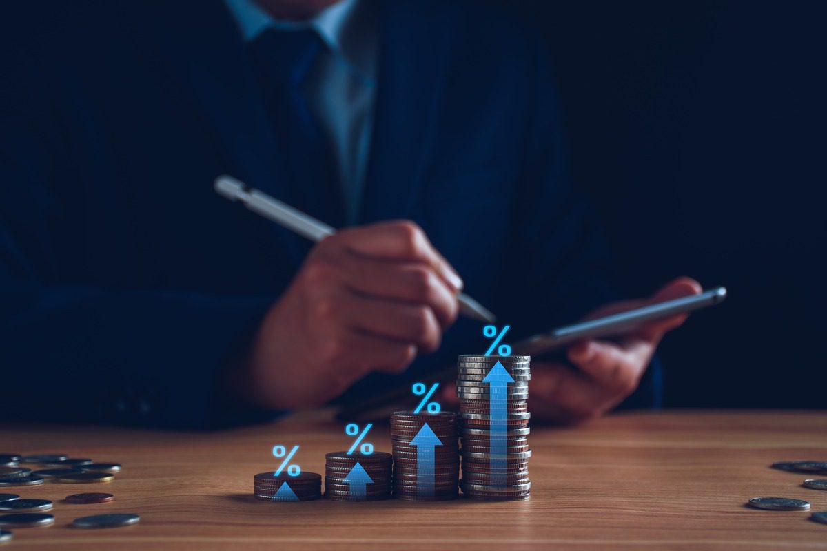 Person using tablet with stacked coins