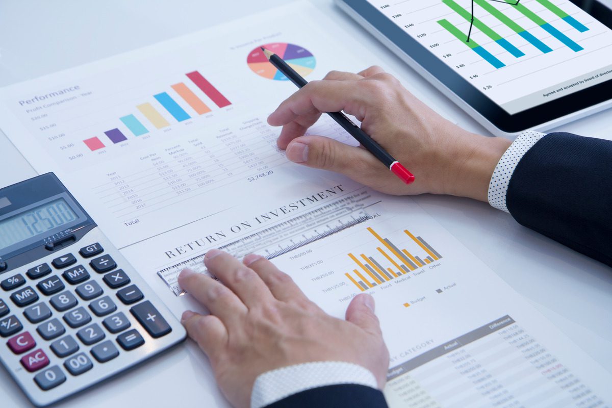 Business analysis report with charts and a tablet displaying financial data visualization.