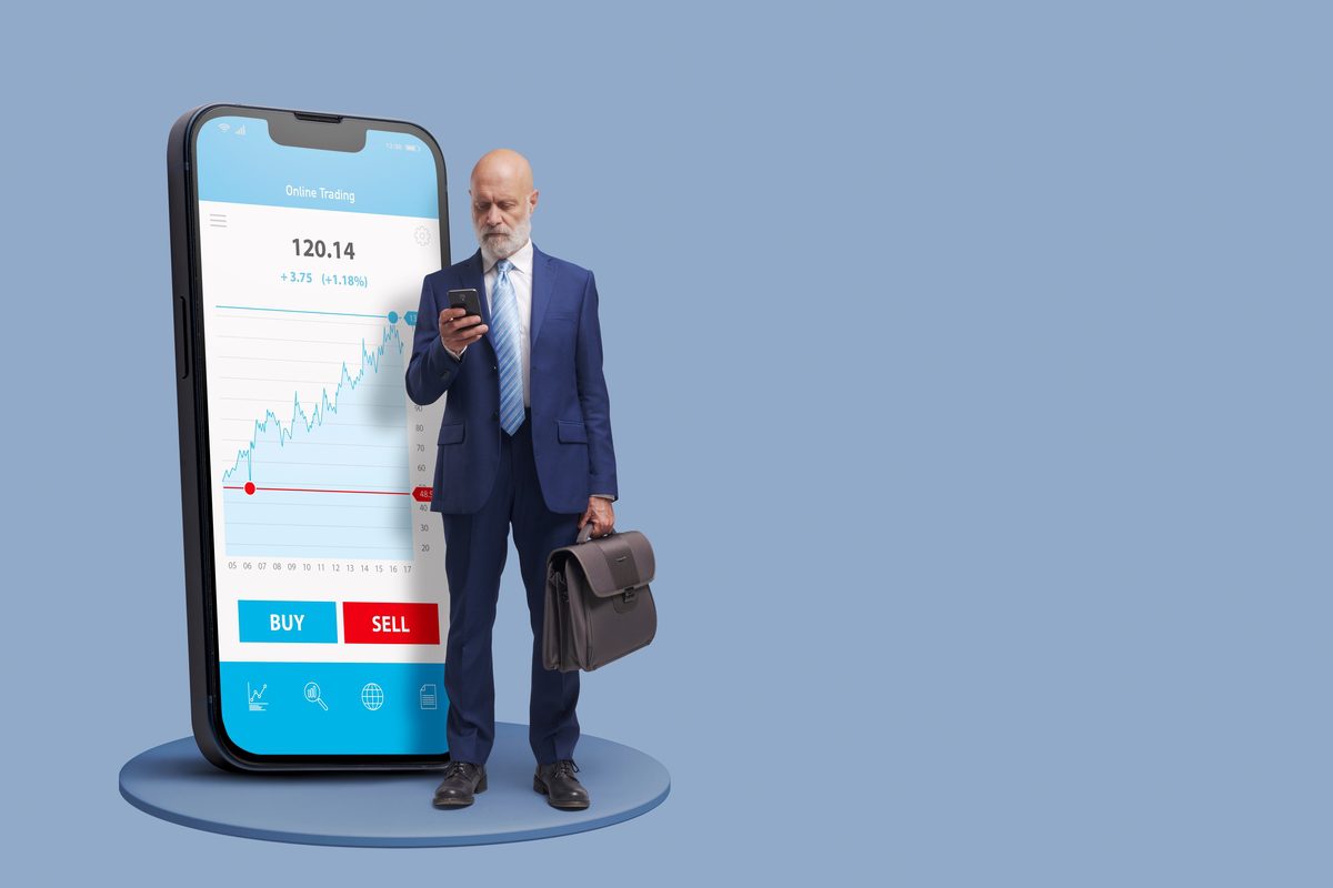 Smartphone displaying a mobile trading app interface with stock growth charts and transaction buttons.